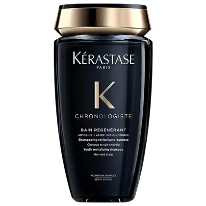 Frasco preto e dourado da linha Chronologiste da Kérastase, contendo um shampoo revitalizante para cabelos e couro cabeludo, com fórmula à base de abissina e ácido hialurônico.