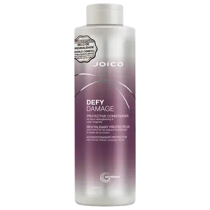 Frasco do condicionador Joico Defy Damage de 1 Litro, com rótulo em tons de roxo e rosa, indicando ser um produto protetor para fortalecimento e prolongamento da cor do cabelo.