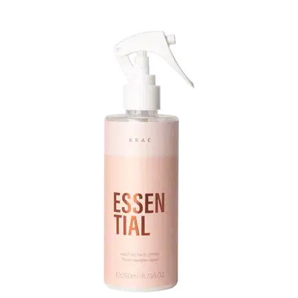 Frasco de spray branco e rosa com rótulo "ESSENTIAL" em letras grandes, contendo fluido reparador capilar da marca Braé.