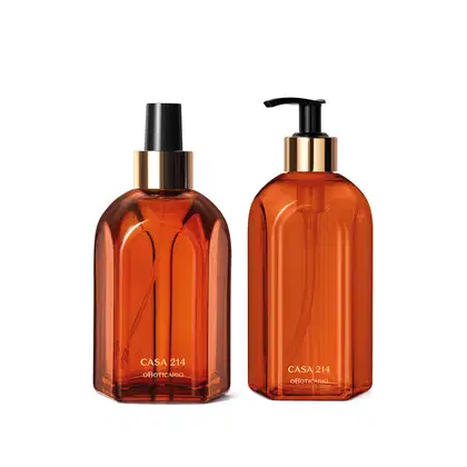 Dois vidros na cor laranja com detalhe dourado e tampa preta da marca Casa 214 Vanilla Sublime, sendo um de 400ml com tampa dosadora de sabonete líquido e outro de 250ml com tampa spray de aromatizador de ambiente.


