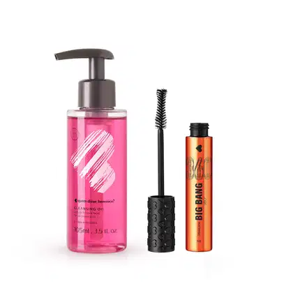 Frasco com líquido rosa, bomba dosadora preta, letras pretas e coração ilustrado na cor branca contendo 105ml de demaquilante Cleasing Oil e tubo de máscara de cílios Big Bang 360 na cor laranja metálico, tampa e aplicador na cor preta.