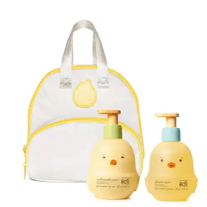 Imagem do Combo Boti Baby que traz uma frasqueira em frasqueira em formato de mochila branca com detalhes amarelos e dois frascos em formato de pintinho amarelo e laranja, contendo um shampoo e um condicional desenvolvido especialmente para crianças.