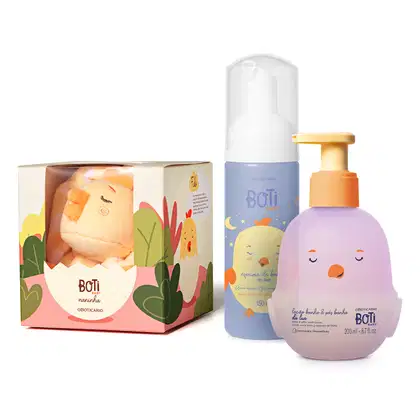 Caixa de presente Boti Baby com naninha, espuma de banho da lua em frasco com bomba e loção corporal em frasco com tampa, com ilustrações e cores suaves em tons de azul, amarelo e laranja.