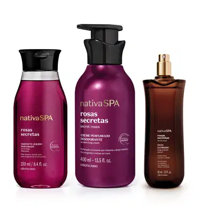 A imagem mostra três produtos da linha Nativa SPA Rosas Secretas, sendo um frasco de sabonete líquido, outro de creme corporal e um vidro de óleo multifuncional. Todas as embalagens são roxas com tampas pretas e rótulo com letras brancas e douradas.