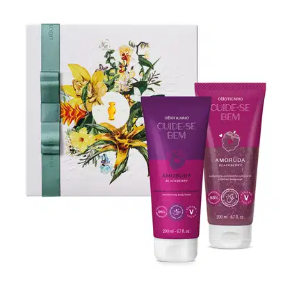 Caixa de presente com flores coloridas e dois frascos de loção corporal da marca Oboticarico Cuide-se Bem, na cor rosa, com rótulo indicando o sabor Amoruda Blackberry.