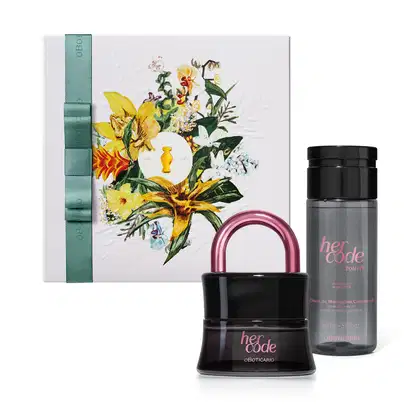 A imagem mostra um kit com uma caixa de presente com ilustração floral, vidro preto em formato de cadeado do sofisticado Eau de Parfum Her Code e frasco em tom acinzentado e tampa preta com rótulo dourado do óleo de massagem da linha Her Code Touch.