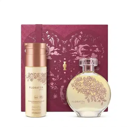Caixa de presente de cor vinho com um grande coração contendo ilustrações em relevo de temática celestial. Ao lado, um frasco de Floratta Gold em embalagem de frasco de vidro rosa claro e flores em alto relevo e frasco de body spray rosa com tampa rosé.