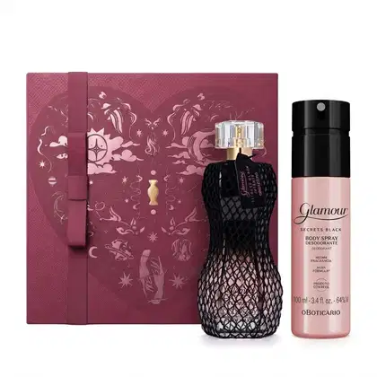 Caixa de presente vinho com um grande coração e ilustrações com temática celestial. Ao lado, frasco de item de perfumaria preto e rosa com rede de tecido preta sobre ele e um frasco de body spray rosa com tampa preta, ambos da linha Glamour Secrets Black.