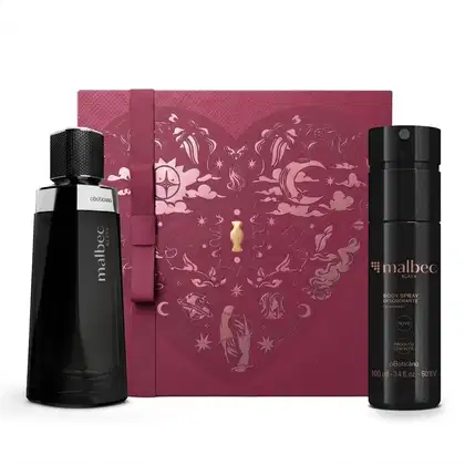 Caixa de presente de cor vinho com um grande coração contendo ilustrações em relevo de temática celestial. Ao lado, dois itens de perfumaria Malbec Black, sendo um frasco de vidro preto com detalhe prata de fragrância e um frasco de body spray preto.