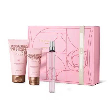Quatro itens Floratta Rose em tons de rosa, vinho e dourado: caixa de presente com ilustrações geométricas[, tubo de 10ml com borrifador prateado de desodorante colônia e duas bisnagas, uma de creme hidratante corporal e creme hidratante para as mãos.