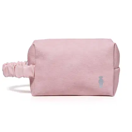 Nécessaire retangular de tecido na cor rosa com alça de transporte franzida e logo da marca O Boticário estampado.
