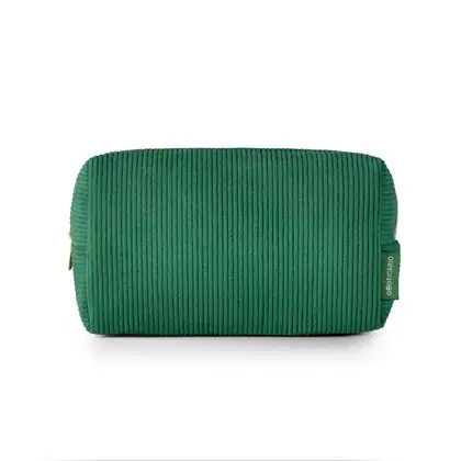 O produto apresentado é uma necessaire de cor verde escuro, com textura canelada. Possui um zíper na parte superior e uma etiqueta com o logotipo da marca O Boticário visível.