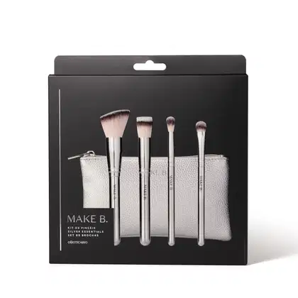 Kit de pincéis de maquiagem Make B. Silver Essentials em embalagem preta contendo um estojo prateado e quatro pincéis com cabos prateados e ponta de cerdas bicolores e macias. O nome da marca está gravada em todos os itens.