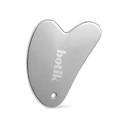 Feito de metal cromado com acabamento espelhado. Apresenta o logotipo "Botik" gravado na superfície em letras brancas. Possui um pequeno orifício circular, possivelmente para pendurar ou prender a uma corrente.