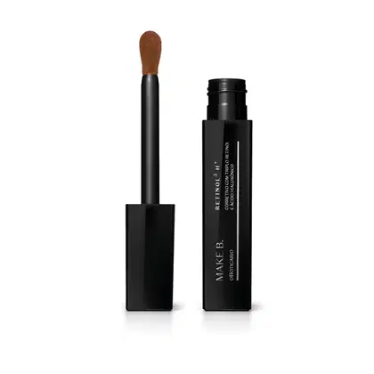 Frasco preto de corretivo líquido da marca Make B. Retinol³ H+ aberto e tampa com aplicador visível na cor preta com ponta em espuma aveludada na cor do produto.