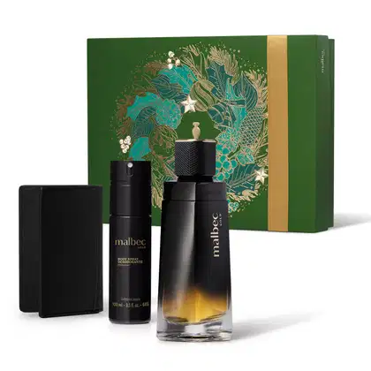 Imagem do Kit Presente Natal Malbec Gold que traz um frasco preto fosco de desodorante colônia, um frasco preto cilíndrico com letras douradas de body spray, uma carteira preta e uma caixa presenteável verde com estampa natalina.