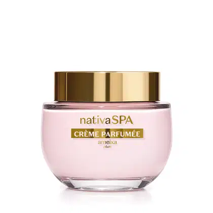 Frasco de vidro de creme perfumado da marca Nativa SPA Ameixa na cor rosada, com tampa dourada e embalagem rosa claro, contendo texto em dourado escrito Crème Parfumée no rótulo.