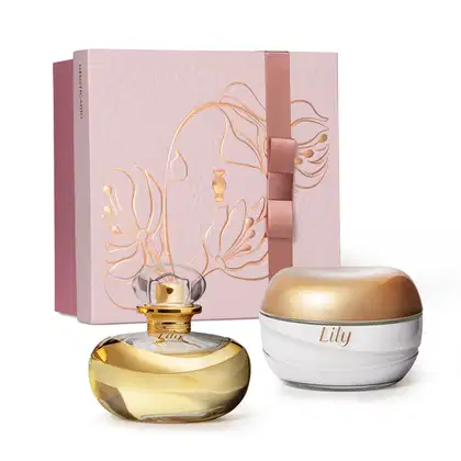 Caixa de presente em tons de rosa e dois produtos da marca Lily, sendo um frasco com líquido bege e tampa dourada de Eau de Parfum e um pote branco com tampa dourada de creme hidratante corporal.