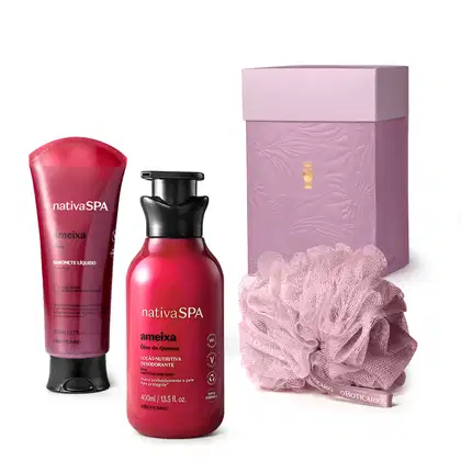 Caixa roxa com detalhe dourado, esponja de banho roxa e dois produtos Nativa SPA Ameixa, sendo uma bisnaga de sabonete líquido corporal e um frasco de loção nutritiva desodorante, ambos em embalagem rosa vibrante com tampa preta.