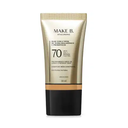 Frasco de base com 8 tipos de ácido hialurônico e probióticos da marca Make B., com FPS 70, UVA+++ e proteção à luz azul. Embalagem em tons de bege e preto, com informações sobre o produto.