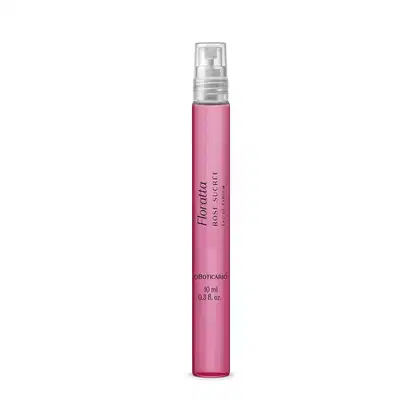 A imagem mostra um frasco de 10ml do Eau de Parfum Floratta Rose Sucrée, em vidro transparente e conteúdo rosa, com rótulo em letras brancas. A tampa é transparente e possui formato cilíndrico.