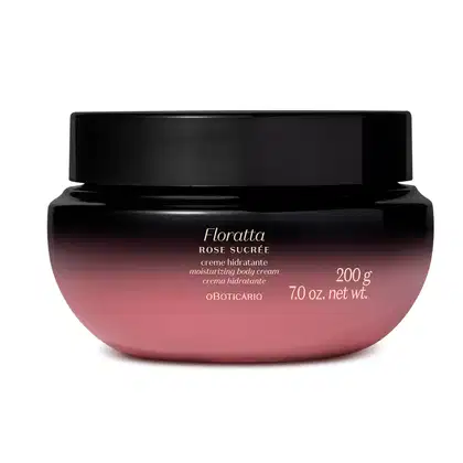 A imagem mostra um pote de creme hidratante corporal da marca Floratta Rose Sucrée. Ele possui um degradê que vai do preto para o roxo, tampa preta e rótulo com informações sobre o produto impresso em letras douradas.