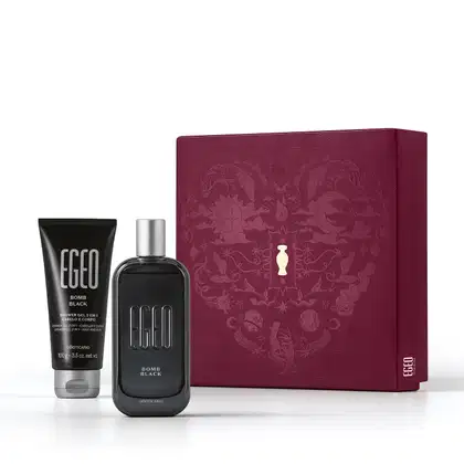 Caixa de presente de cor vinho com um grande coração ilustrado detalhes de temática celestial. Ao lado, itens de perfumaria da marca  Egeo Bomb Black, sendo um frasco de desodorante colônia preto e bisnaga de gel de banho preta, ambas com tampa prateada.