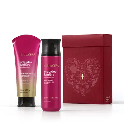 Caixa de presente de cor vinho com um grande coração ilustrado detalhes de temática celestial. Ao lado, itens de perfumaria da marca Nativa SPA Orquídea Lumière, sendo uma bisnaga de creme corporal perfumado e body spray, ambos cor-de-rosa com tampa preta