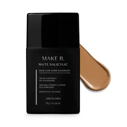 Frasco preto de base da linha Make B. Mate Salicylic com texto em branco trazendo informações do produto, como presença de ácido salicílico, controle de oleosidade e resistência ao suor. Atrás da embalagem, vemos um pouco de base bege clara espalhada.