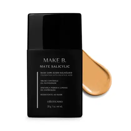 Frasco preto de base da linha Make B. Mate Salicylic com texto em branco trazendo informações do produto, como presença de ácido salicílico, controle de oleosidade e resistência ao suor. Atrás da embalagem, vemos um pouco de base bege clara espalhada.