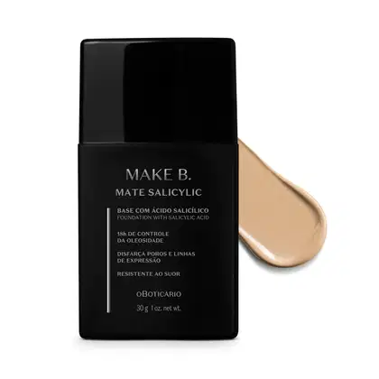 Frasco preto de base da linha Make B. Mate Salicylic com texto em branco trazendo informações do produto, como presença de ácido salicílico, controle de oleosidade e resistência ao suor. Atrás da embalagem, vemos um pouco de base bege bem clara espalhada.