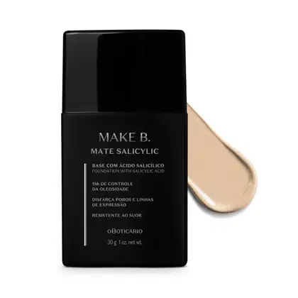 Frasco preto de base da linha Make B. Mate Salicylic com texto em branco trazendo informações do produto, como presença de ácido salicílico, controle de oleosidade e resistência ao suor. Atrás da embalagem, vemos um pouco de base bege bem clara espalhada.