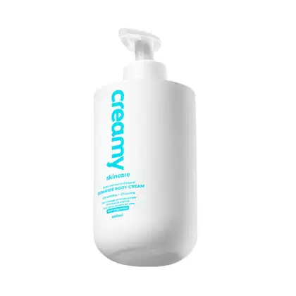 Frasco branco de 400ml de creme corporal da marca Creamy, com rótulo azul destacando o nome "Creamy Skincare" e informações sobre o produto.