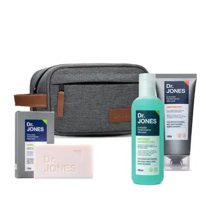 Conjunto de produtos de cuidados pessoais da marca Dr. Jones, incluindo um estojo de viagem cinza, um sabonete, um gel de banho e um creme para a barriga.