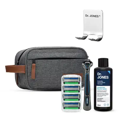 Estojo de viagem cinza com produtos de barbear da marca Dr. Jones, incluindo um barbeador elétrico, lâminas de reposição e um frasco de shampoo para barba com carvão.