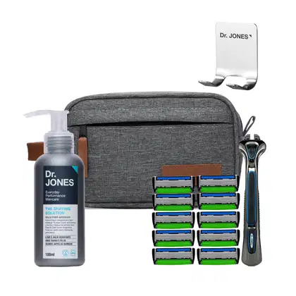 O conjunto de produtos Dr. Jones inclui um frasco de solução de barbear, uma lâmina de barbear com 10 lâminas de reposição e uma bolsa de transporte cinza com detalhes em couro.