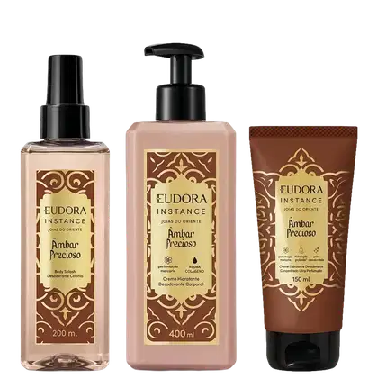 Três produtos Eudora Instance Âmbar Precioso: Body Splash 200ml com spray, Creme Hidratante Desodorante Corporal 400ml com bomba, e Creme Desodorante 150ml em tubo. Embalagens marrom e bege com detalhes dourados ornamentais.