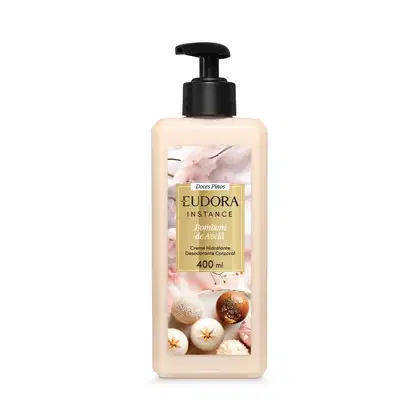 Embalagem plástica transparente com imagem de bombom de açúcar na cor bege, nozes, especiarias e flores decorativas no rótulo. Retângulo dourado com o nome Eudora Instance Bombom de Avelã 400ml em letras pretas e brancas. Bomba dosadora preta como tampa.