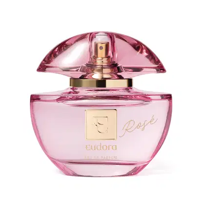 Frasco do Eau de Parfum Eudora Rosé. O frasco é feito de vidro rosa com detalhes em dourado. Na parte frontal, está gravado o nome "Rosé" em letras douradas cursivas. O topo do frasco tem uma tampa em vidro que deixa entrever a parte dourada do borrifador