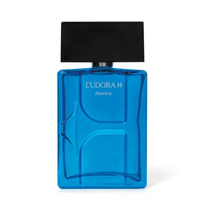 Frasco transparente do Desodorante Colônia exibindo a cor azul de um dia de sol na praia, com design moderno formando a leta H na embalagem. Tampa na cor preta, larga, remetendo à letra H. Rótulo na parte superior do frasco escrito Eudora H Marine.