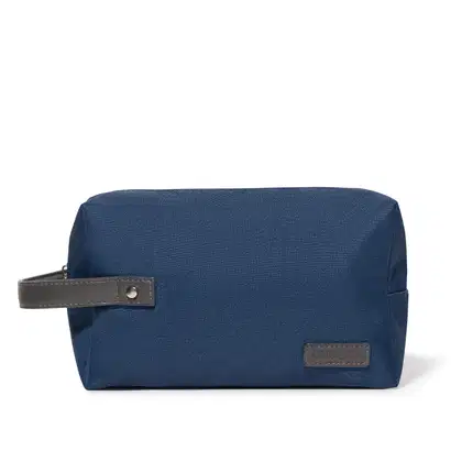 Necessaire de viagem de cor azul marinho, com zíper e alça de couro, com a marca Eudora impressa em relevo na parte frontal.