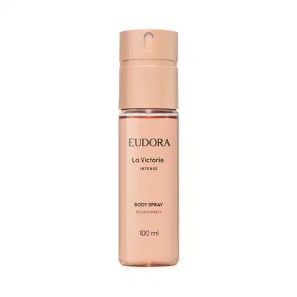 Embalagem cilíndrica de plástico rígido na cor nude rosado. Rótulo com o nome do produto "La Victorie Intense Body Spray Desodorante" e a informação de volume de 100ml. Tampa tipo spray na parte superior. Design minimalista e elegante.