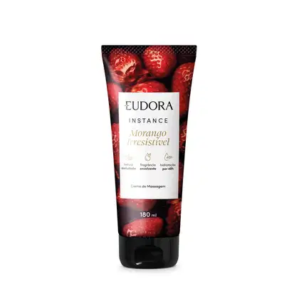 O produto apresentado é um creme de massagem da linha Instance da marca Eudora. A embalagem é um tubo plástico vermelho com uma imagem de morangos em destaque. O rótulo contém o nome do produto "Morango Irresistível".
