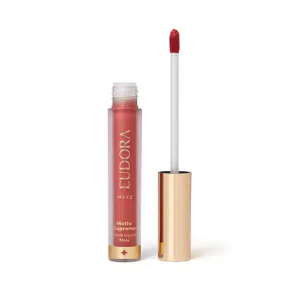Batom Líquido Matte Supreme em embalagem transparente com tampa dourada e aplicador do tipo bastão. Produto com design minimalista e rótulo dourado no frasco.