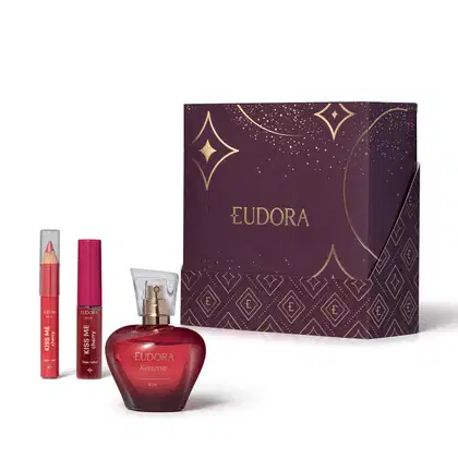 Conjunto de produtos da marca Eudora: Desodorante Colônia KissMe, o Gloss Labial e o Lápis Multifuncional na cor Cherry. Com uma caixa decorada com padrões dourados e estrelas em fundo roxo escuro, indicando ser um kit presente dia dos namorados.