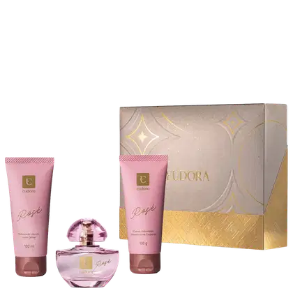 Kit Eudora Rosé contém sabonete líquido com glitter (100ml), perfume em frasco de vidro rosa, creme hidratante desodorante corporal (100g). Embalagem bege com detalhes dourados e padrão geométrico.