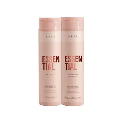 Dois frascos de shampoo e condicionador da linha Essential da marca Braé, com embalagens rosadas e rótulos em vermelho destacando o nome "Essential".