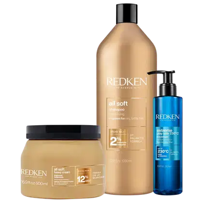 Produtos Redken incluem um frasco de shampoo All Soft, um pote de creme All Soft Heavy e um frasco do tratamento Extreme Play Safe 230°C, todos com embalagens em tons de dourado e azul.