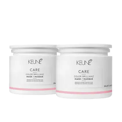 Dois potes brancos da linha Keune Care, contendo a máscara de tratamento Color Brillianz, que protege cabelos coloridos. Os potes possuem rótulos com o nome da marca e do produto, além de informações sobre sua função.