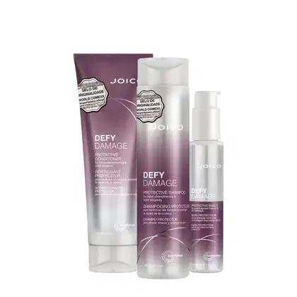 Produtos Joico Defy Damage: shampoo protetor, condicionador protetor e escudo protetor para cabelos, em embalagens de plástico e vidro com cores roxas e brancas.